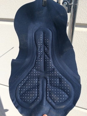 Black cycling chamois pad hanging on a rail.